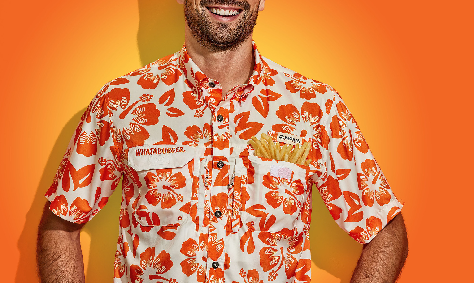 Close-up of a smiling man wearing an orange-and-white Whataburger patterned shirt.