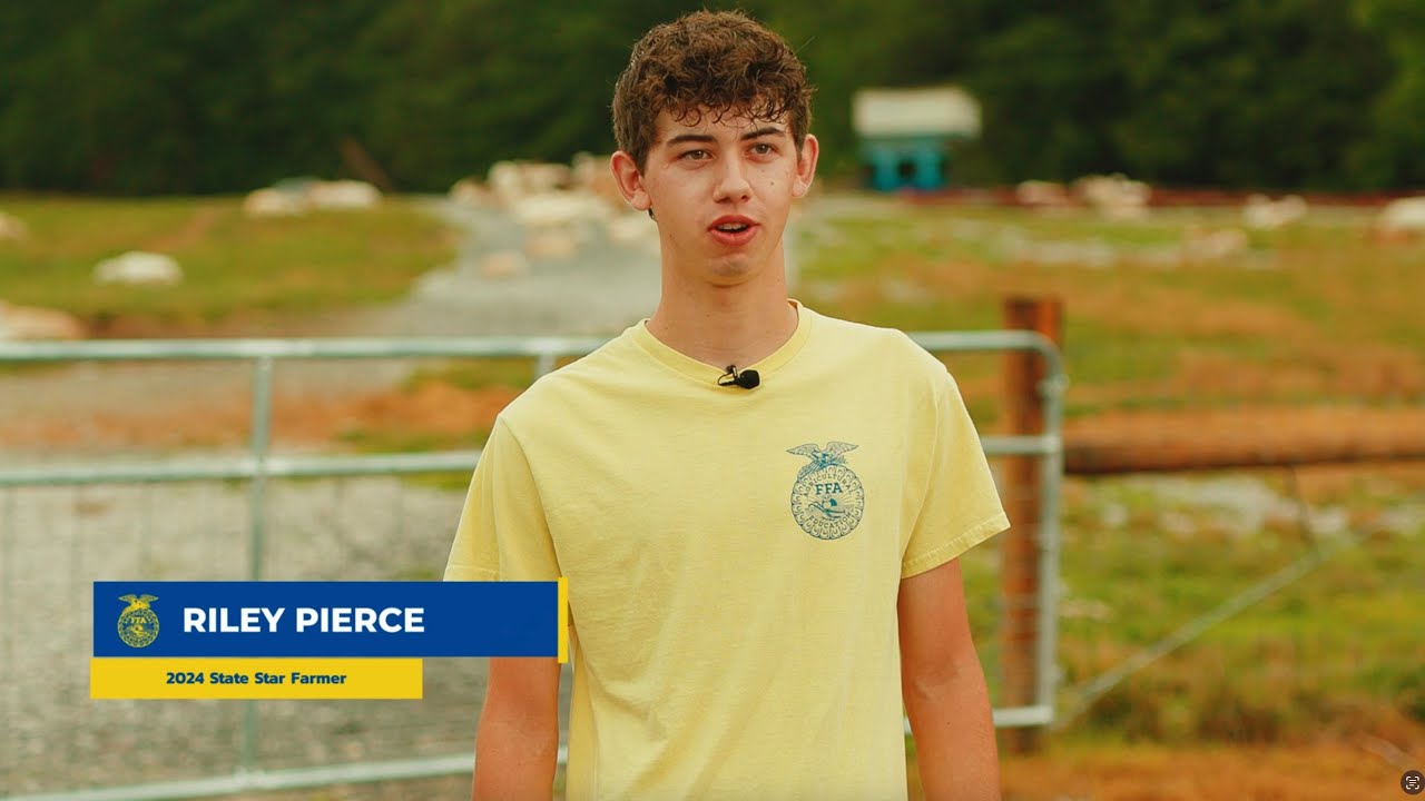 Interview preview of Riley Pierce wearing a yellow shirt outside near a livestock pen.