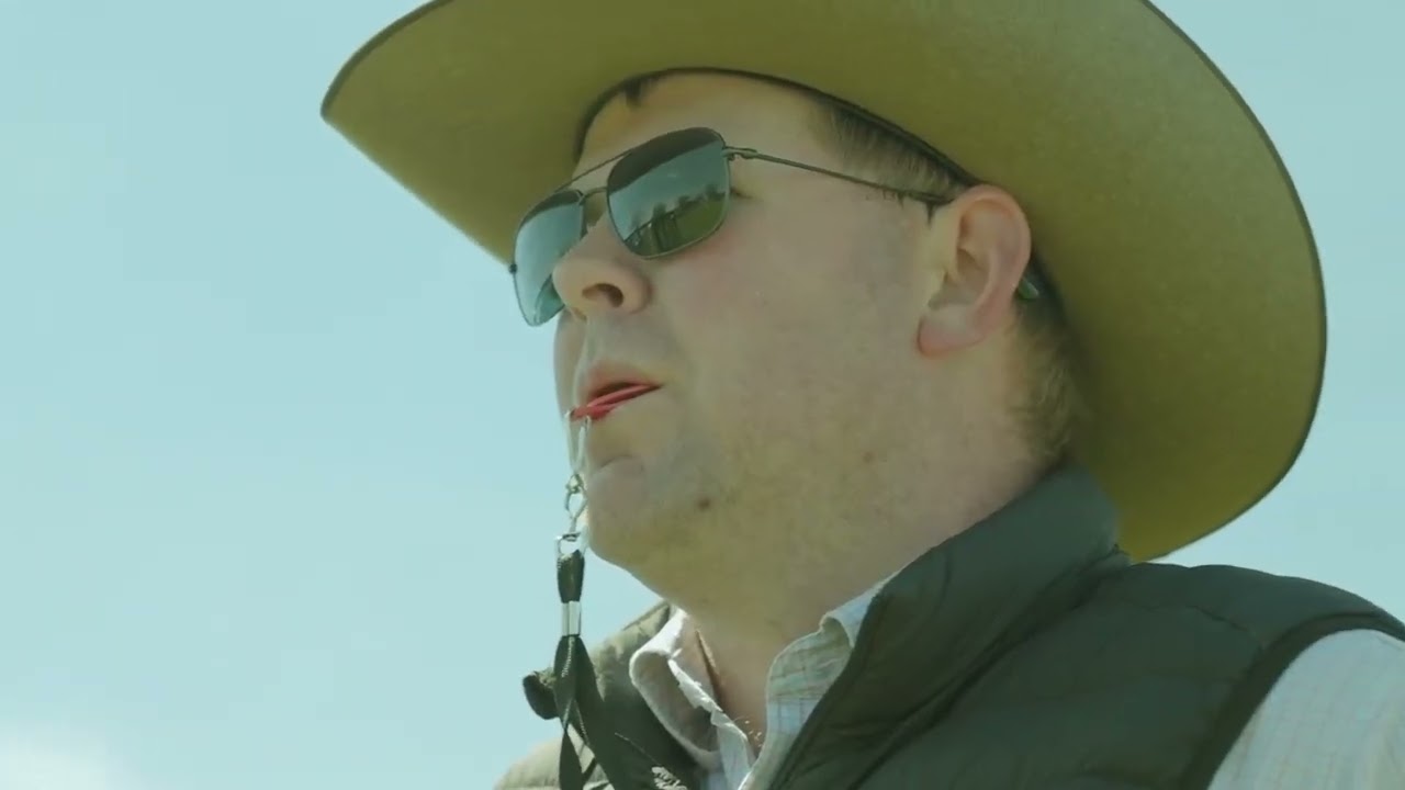 Film preview of a person in a cowboy hat and sunglasses against a blue sky.